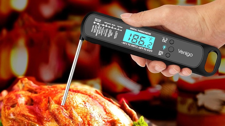 Person checking temperature of a roasted chicken with a Venigo thermometer