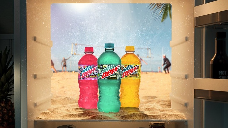 Three Baja Blast flavored Mountain Dews with beach background.