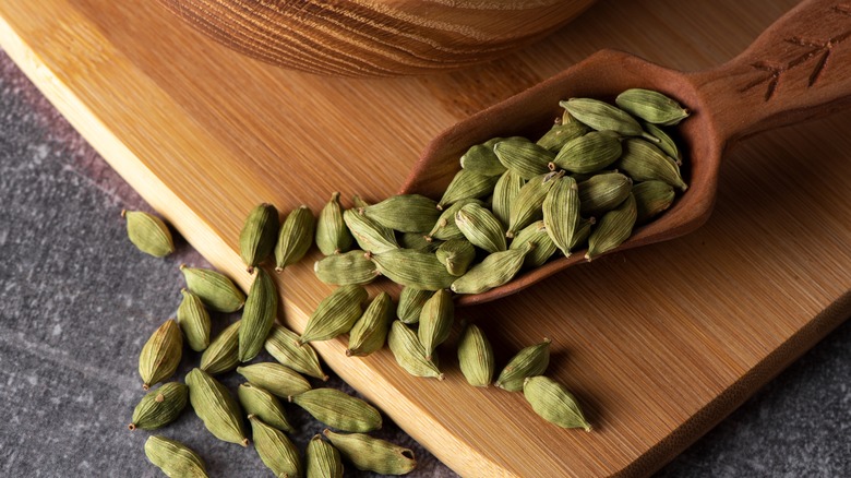 wooden scoop of green cardamom