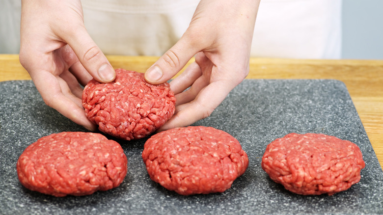 Hands forming hamburger patties