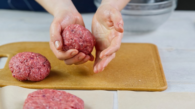 Hands forming raw beef patties