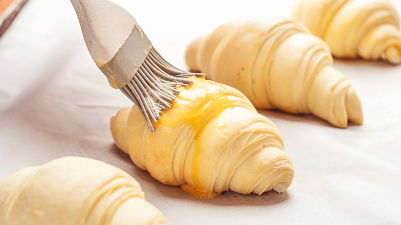 Brushing egg wash on croissants