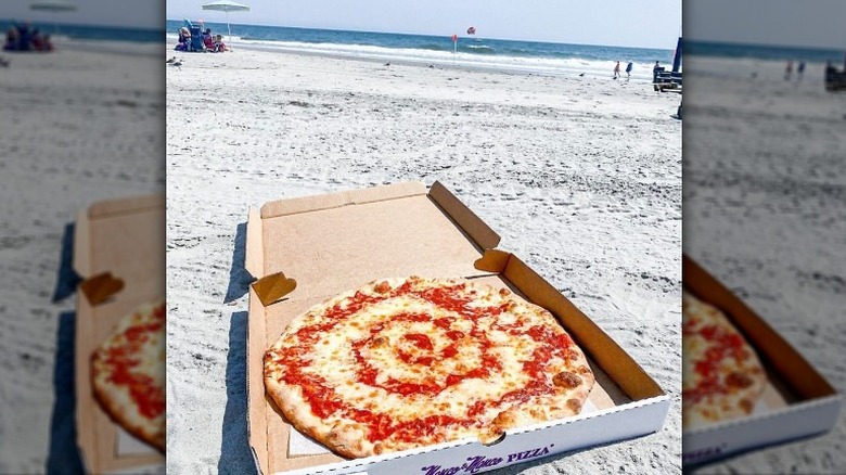 box of pizza on sand