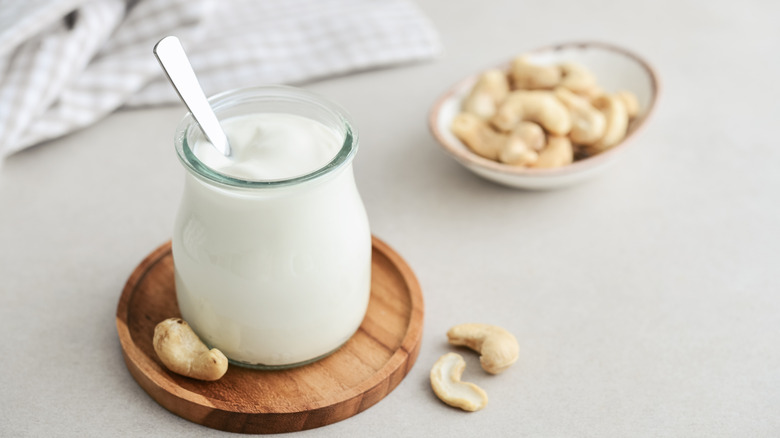 Cashew cream in jar with cashews in bowl