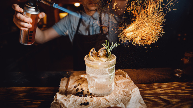 Bartender blowtorching cocktail