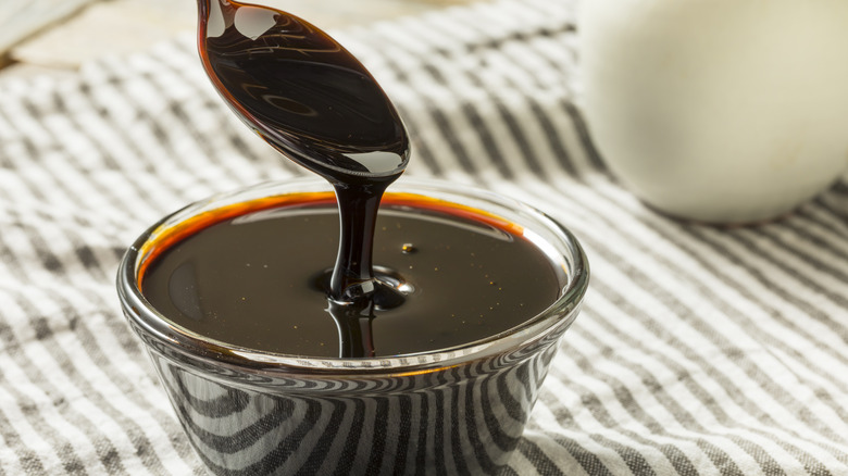 Black molasses poured with spoon