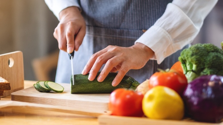 chopping zucchini and other veggies