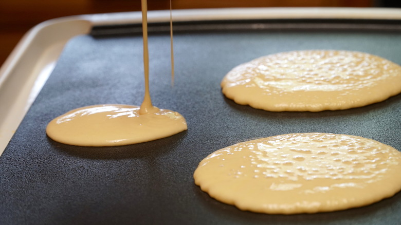 Pouring pancake batter on griddle