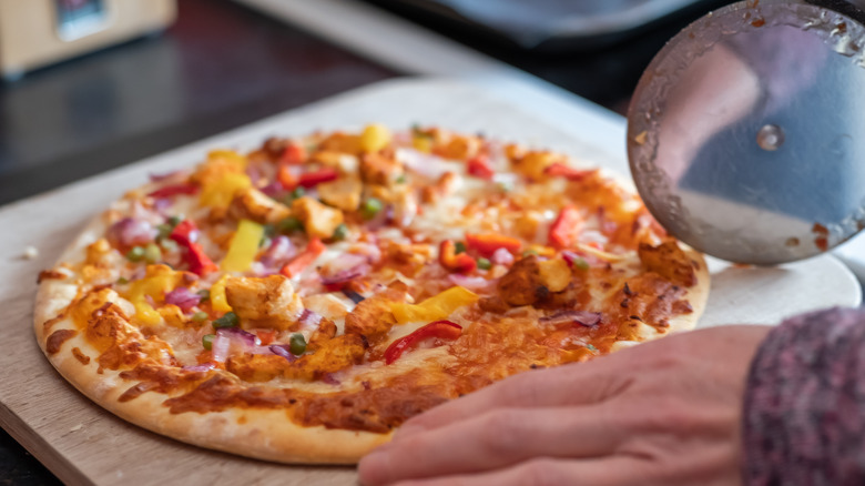 Person cutting into pizza 