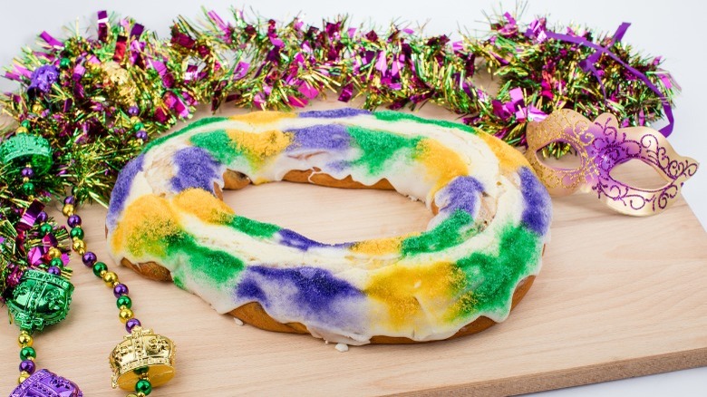 Purple, gold, and green beads around a similar colored cake