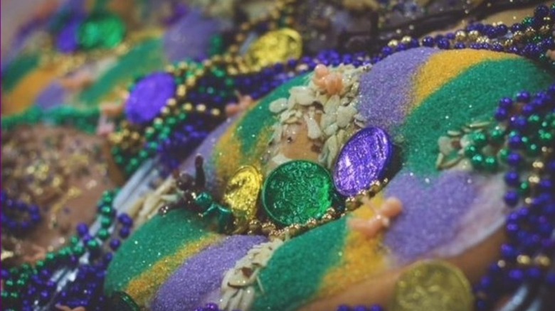 Purple and gold coins over a similar color king cake