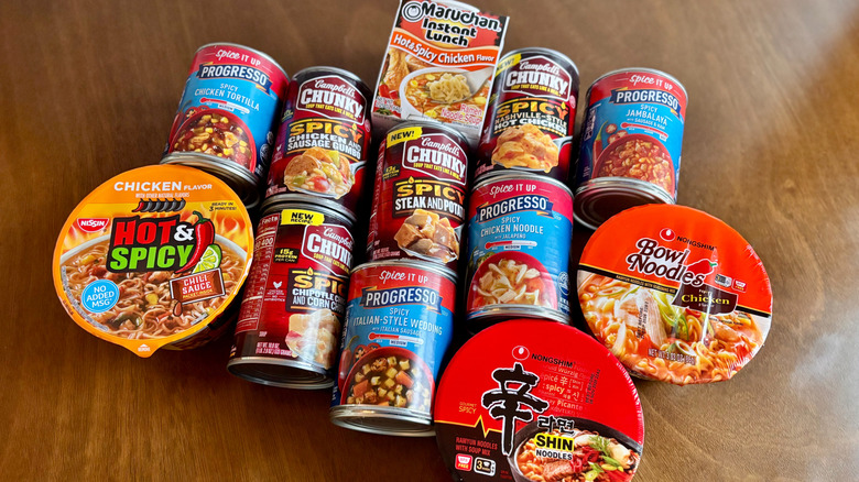 Various canned soups and ramens laid out on table