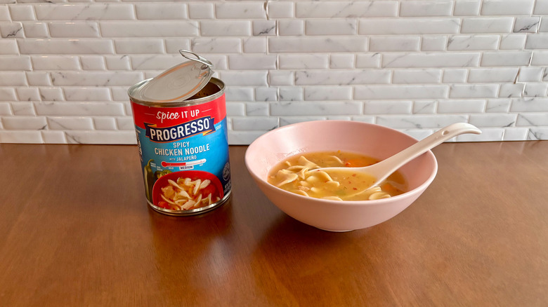 Can of Progresso soup next to bowl of chicken noodle soup