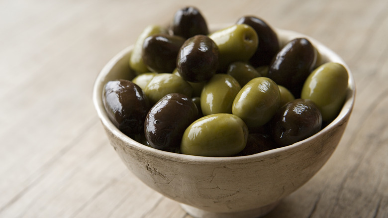 bowl of olives on wood background