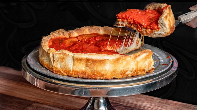 Slice being removed from a deep dish pizza from Carmine's