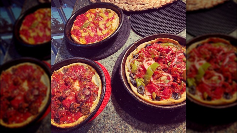 Three deep dish pizzas in pans from Mr. Gilberti's Place