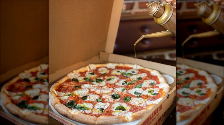 Pouring oil onto boxed pizza