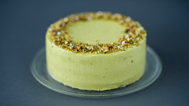 Green frosted cake and pistachios