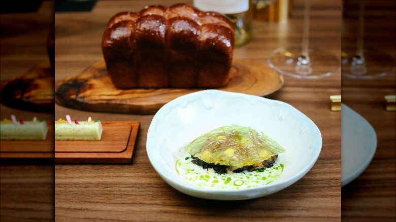 bread and liquid in dish at Artelier Crenn