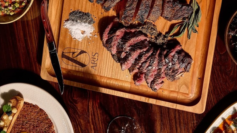 Doris Metropolitan sliced steak on wooden cutting board