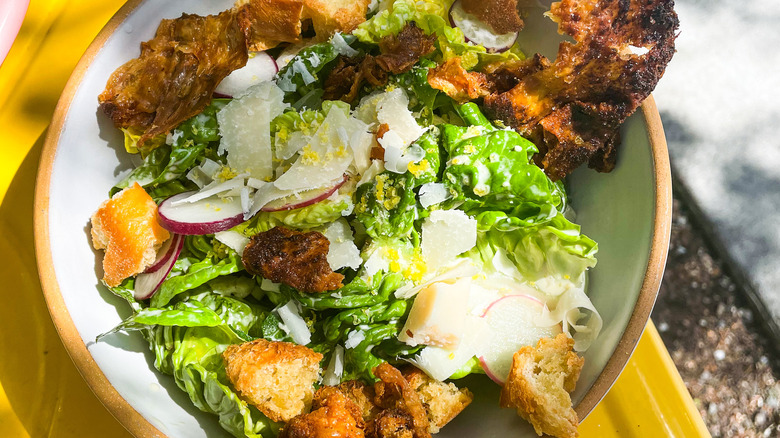 Caesar salad with chicken skins