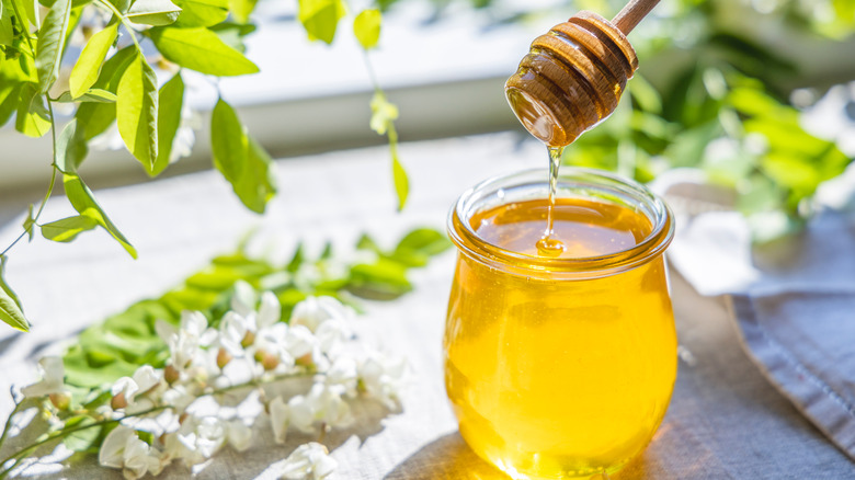 Honey pouring into jar