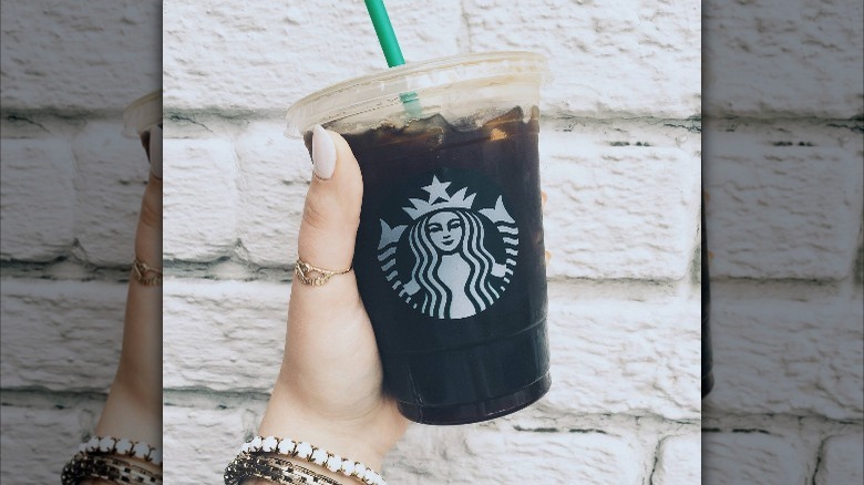 Hand holding an Iced Americano