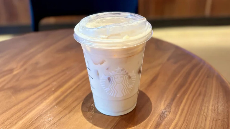 plastic cup of iced chai tea latte on a wooden table