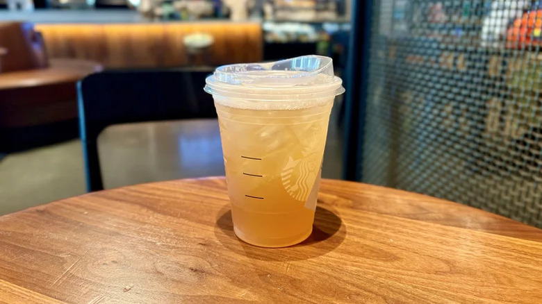 iced peach green tea lemonade on a wooden table inside a coffee bar