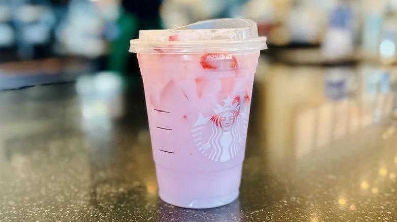 pink drink cup from starbucks on a dark counter