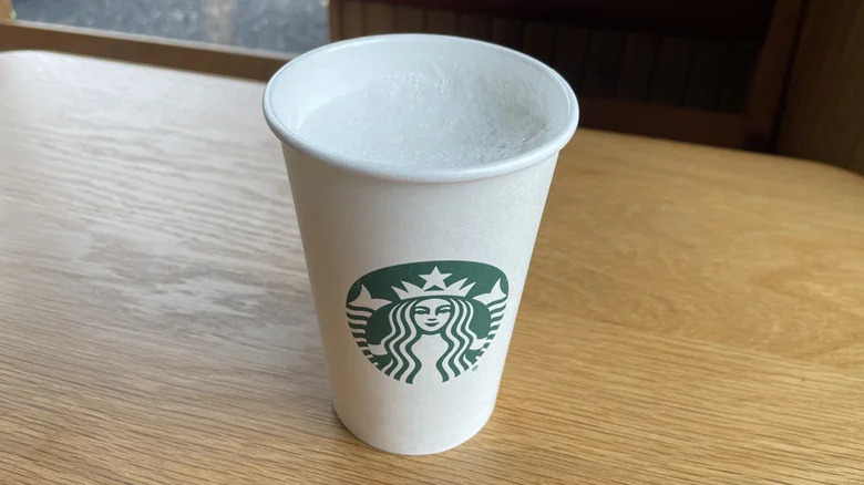 vanilla creme starbucks drink ina a white paper cup on a wooden table