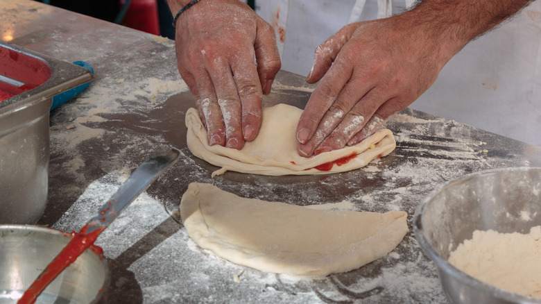 Hands making calzone