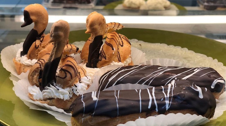 Chocolate eclair and a pastry shaped like swans on a plate
