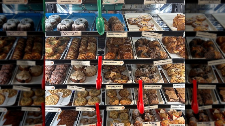 Pastry case full of various baked goods with tongs
