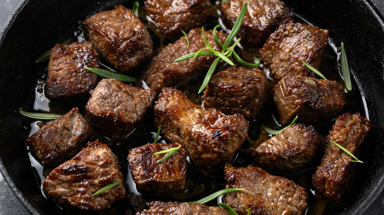 Steak tips in a pan with herbs