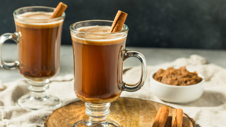 Two hot buttered cocktails with cinnamon sticks