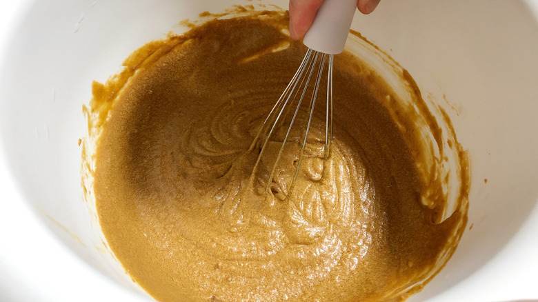 hand whisking dark batter in a bowl