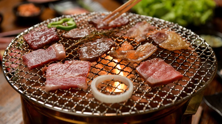 Thinly sliced meats on tabletop grill