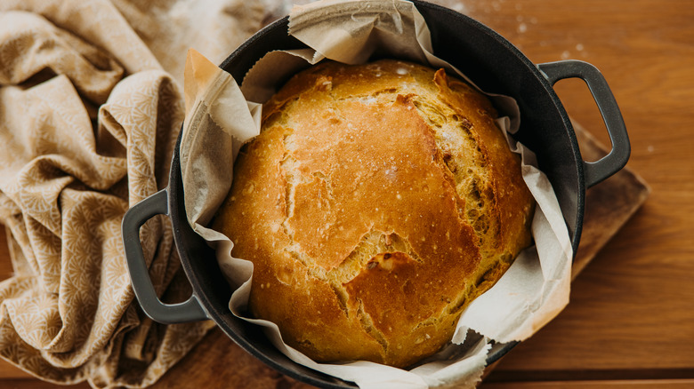 Gold-brown baked boule in a cast iron Dutch oven