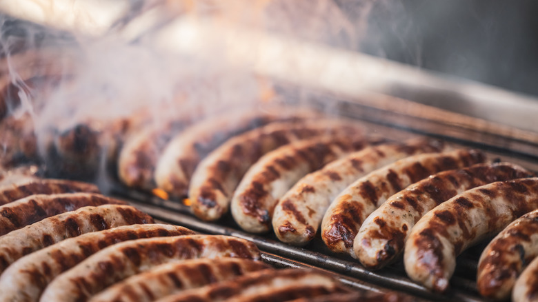 sausages over smoking grill