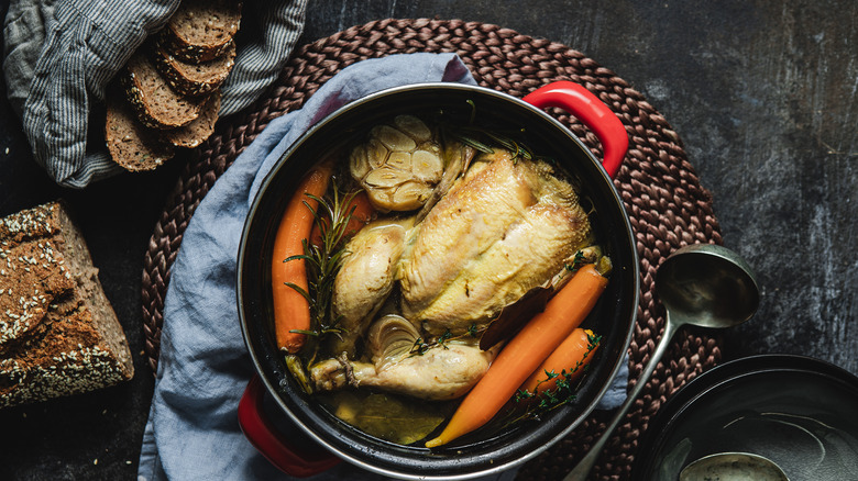 Whole chicken in broth with garlic and carrots