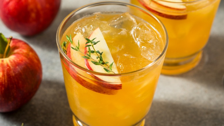 Apple juice in a glass with ice and apple slice garnishes