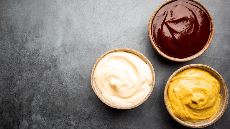 bowls of mayo, barbecue sauce and mustard