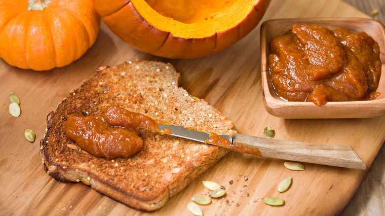 Toast with pumpkin butter, knife, and pumpkins