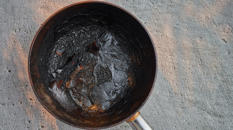 empty burnt sauce pan on cement 