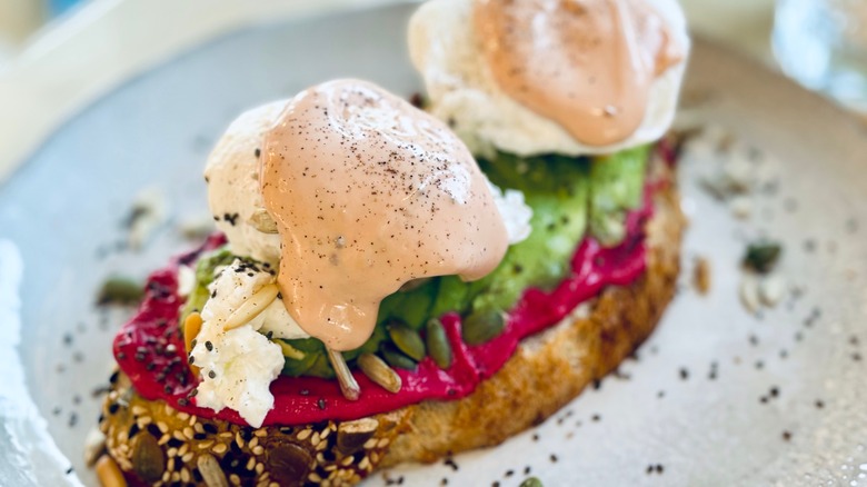 Poached eggs on hummus and avocado toast