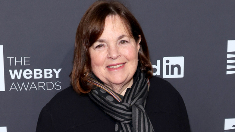 Ina Garten smiling in black button down and gold necklace