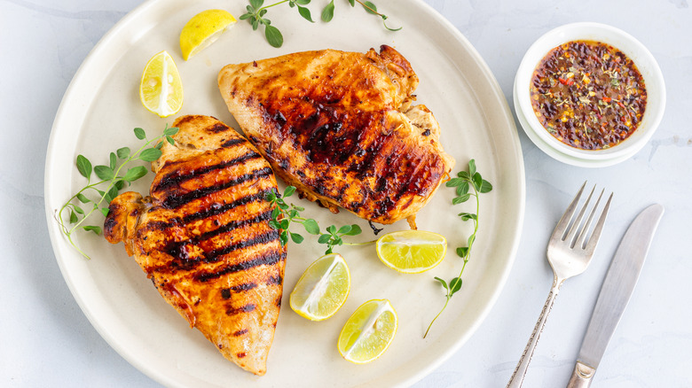 grilled chicken on a plate with lemons