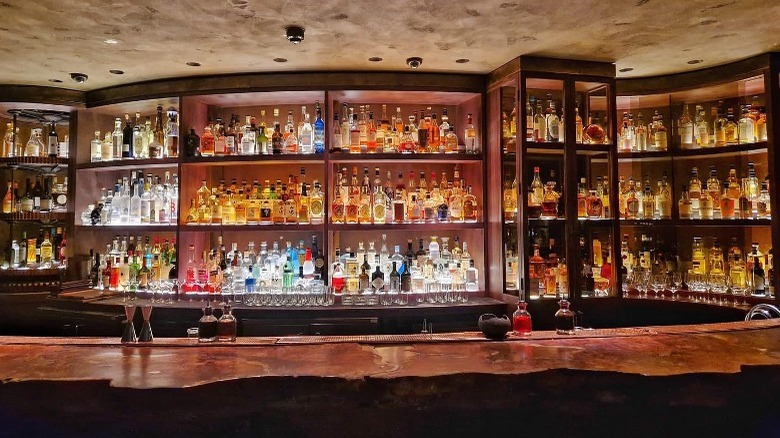 dark and moody bar with back lit alcohol