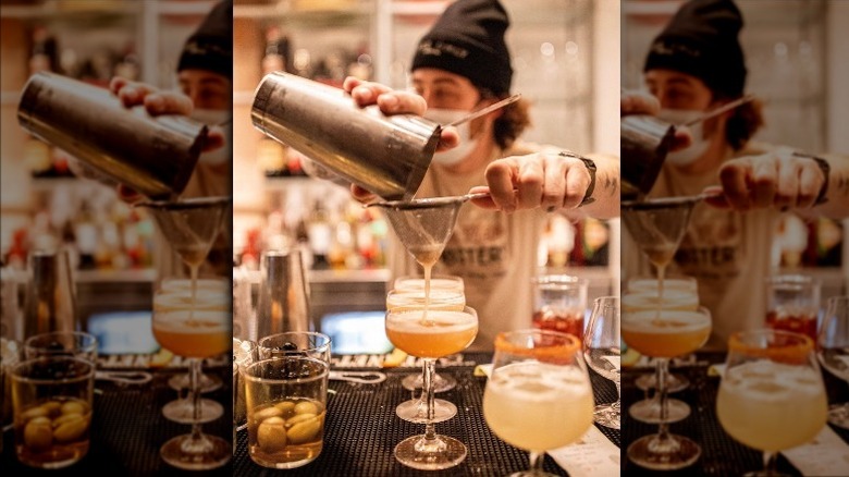 cocktail being strained into a glass